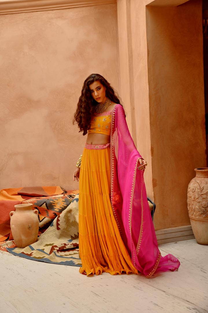 Image of Turmeric yellow tier lehenga with blouse and dupatta.