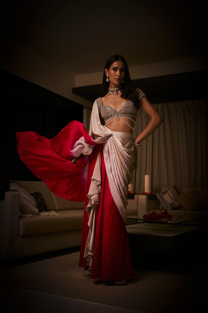 A pure silk satin pre-draped saree in dusty pink and sangria ombré, paired with a cutdana and pearlembellished blouse .