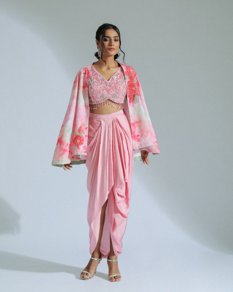 A Georgette cape in pink and sage ombré tones adorned with organza floral patterns and an inner hand-embroidered blouse with a pink modal satin lungi drape. 