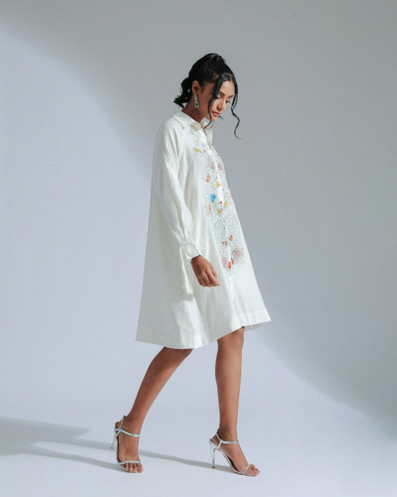White shirt dress with intricate lace, beadwork, and charming motifs. 