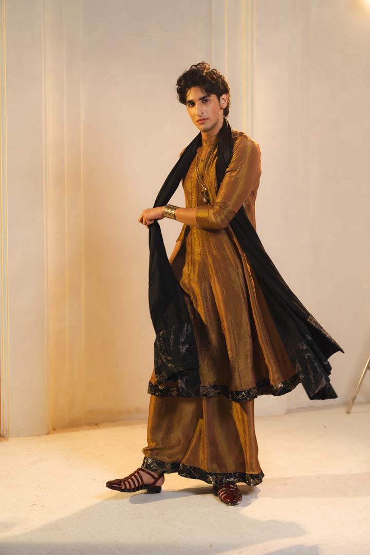 Anarkali kurta in gold, paired with flared trousers and a contrasting black dupatta.