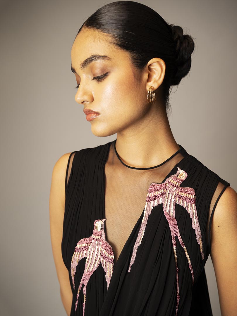 Black drape saree gown with pink 
embellished detailing and sheer neckline.