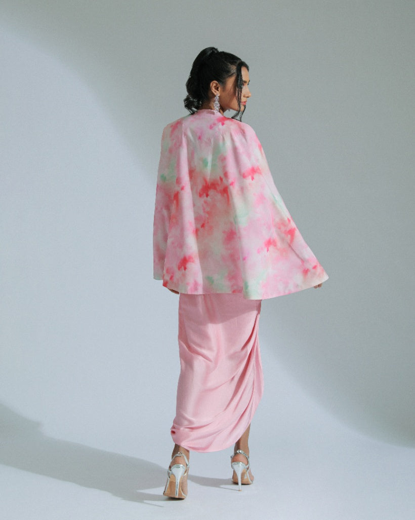 A Georgette cape in pink and sage ombré tones adorned with organza floral patterns and an inner hand-embroidered blouse with a pink modal satin lungi drape. 