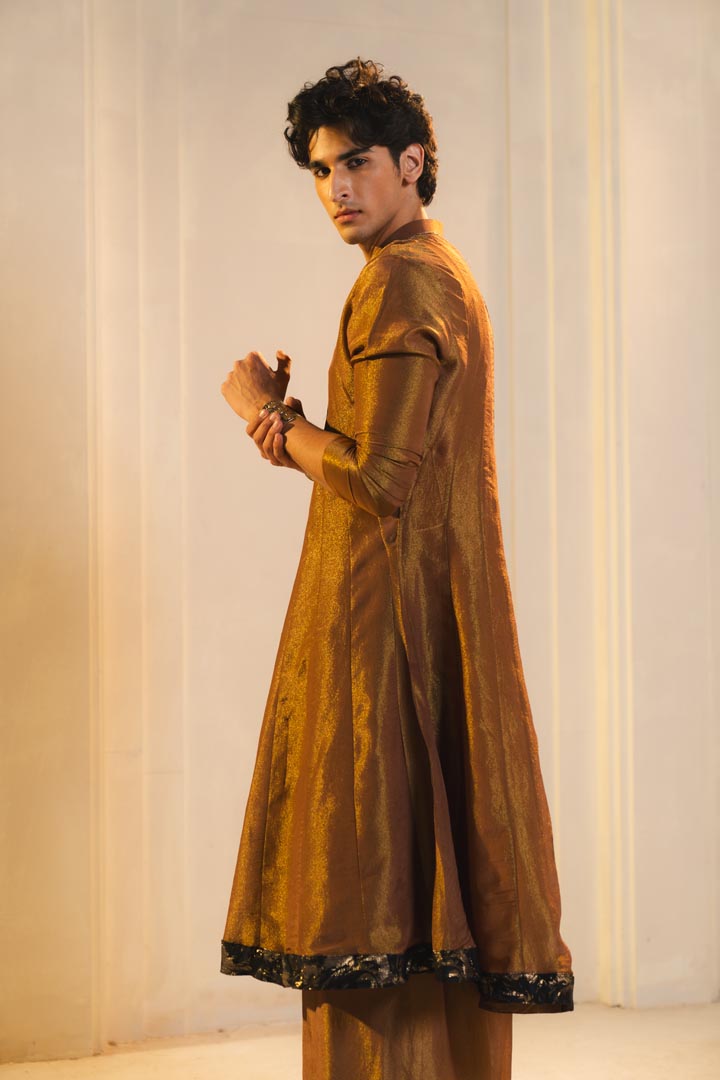 Anarkali kurta in gold, paired with flared trousers and a contrasting black dupatta.
