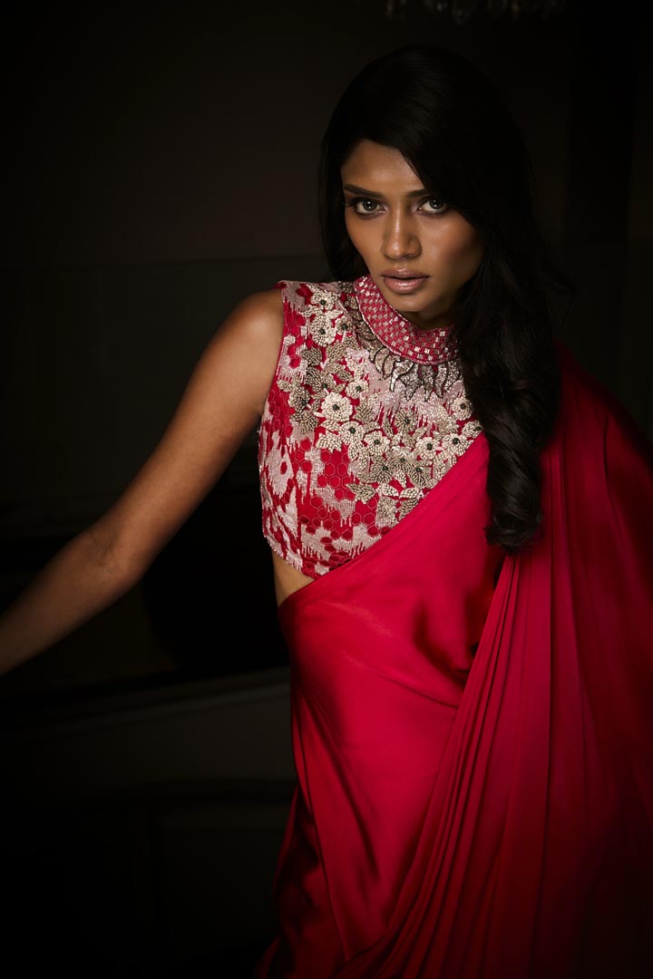 A sangria silk satin pre-draped saree paired with an intricately embroidered blouse.