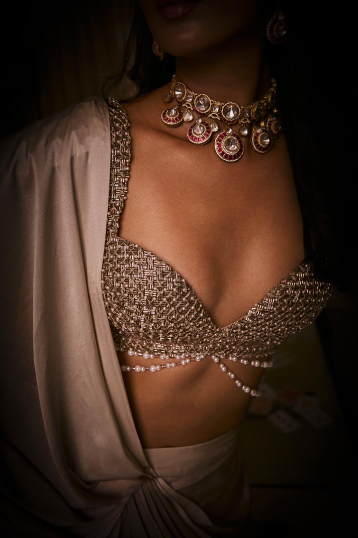 A pure silk satin pre-draped saree in dusty pink and sangria ombré, paired with a cutdana and pearlembellished blouse .