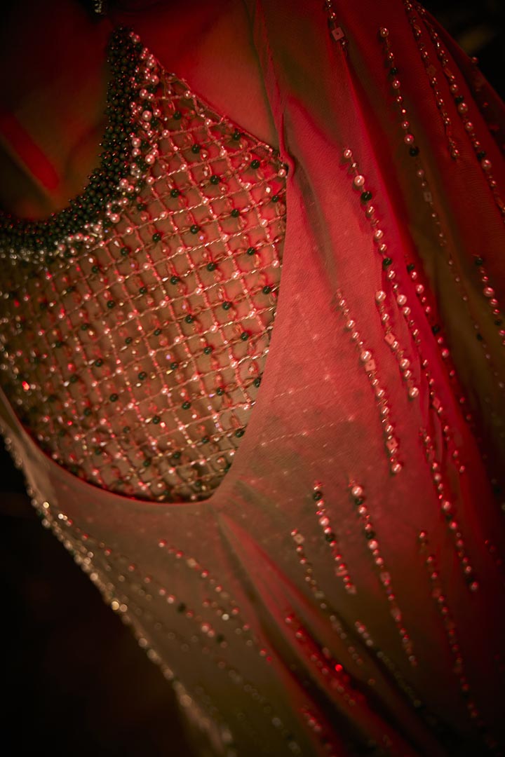 Taupe three-piece ensemble featuring a draped skirt, structured blouse, and a sheer embellished cape.