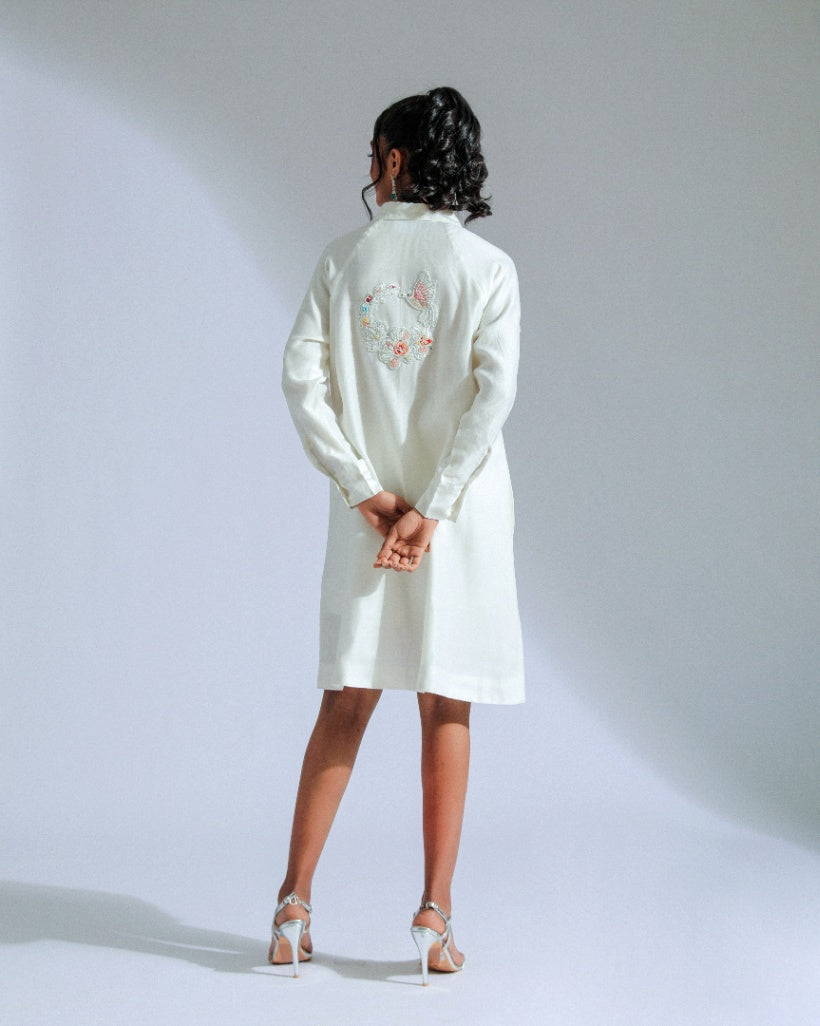 White shirt dress with intricate lace, beadwork, and charming motifs. 