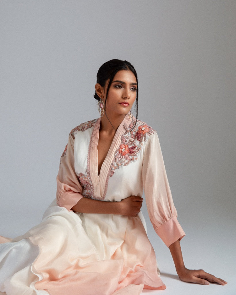 An off-white to Champagne ombré handkerchief-cut asymmetrical drape with a one-side tie and floral motifs. 