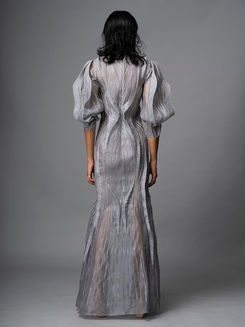 Silver embellished gown with
 sheer detailing and dramatic puff sleeve