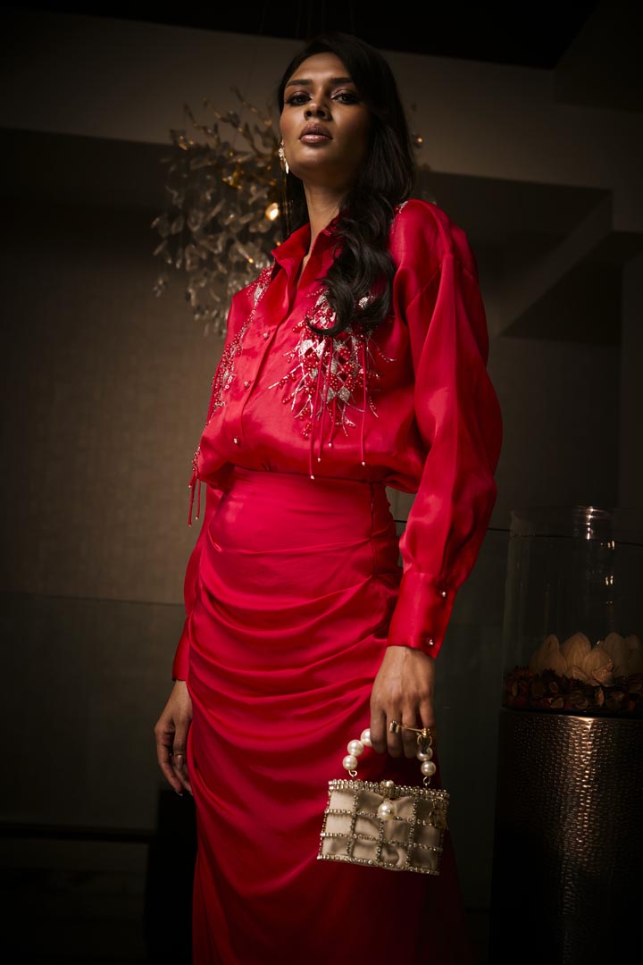 A sangria silk satin cowl skirt paired with an organza shirt, delicately hand-embroidered with sequins and beads.