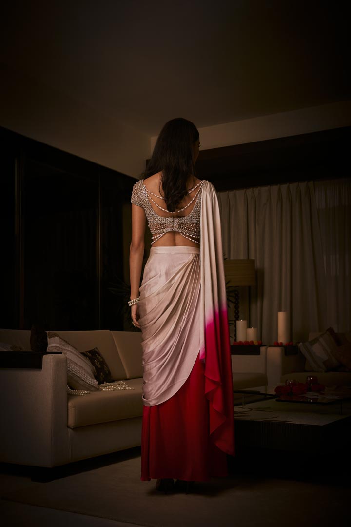 A pure silk satin pre-draped saree in dusty pink and sangria ombré, paired with a cutdana and pearlembellished blouse .