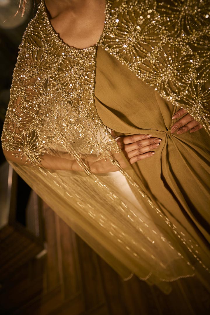 Olive green dress paired with an embellished sheer cape