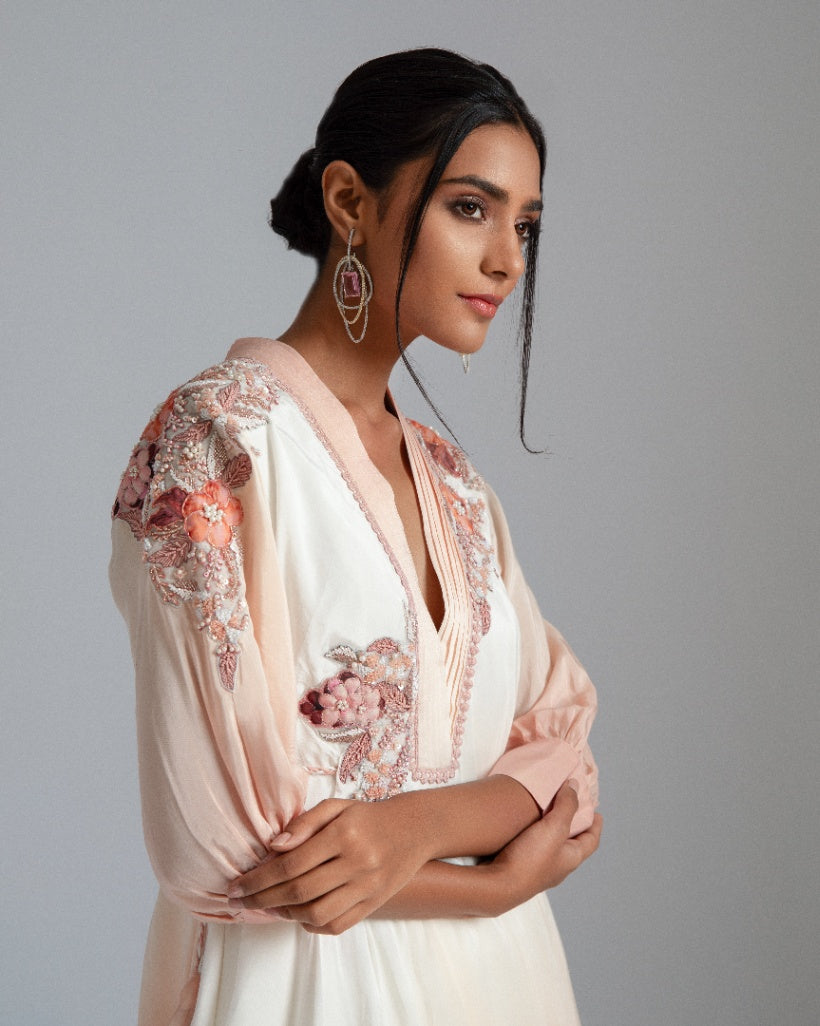 An off-white to Champagne ombré handkerchief-cut asymmetrical drape with a one-side tie and floral motifs. 