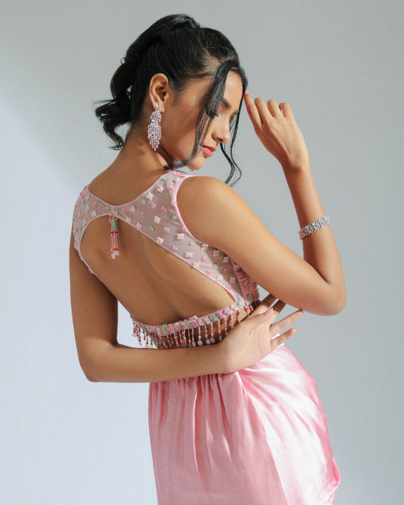 A Georgette cape in pink and sage ombré tones adorned with organza floral patterns and an inner hand-embroidered blouse with a pink modal satin lungi drape. 