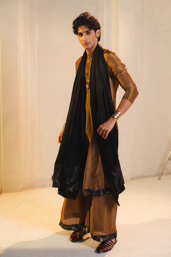 Anarkali kurta in gold, paired with flared trousers and a contrasting black dupatta.