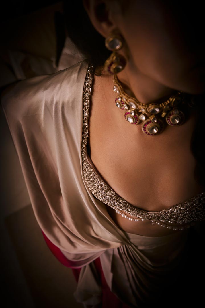A pure silk satin pre-draped saree in dusty pink and sangria ombré, paired with a cutdana and pearlembellished blouse .