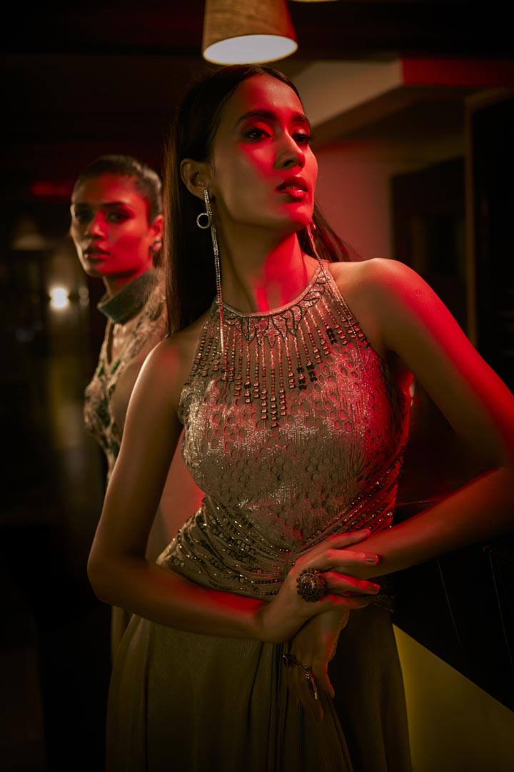 A taupe crushed fabric jumpsuit gown with intricate bead embroidery for a refined, modern silhouette.