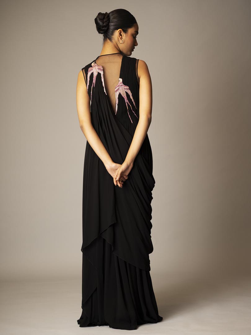 Black drape saree gown with pink 
embellished detailing and sheer neckline.Â”