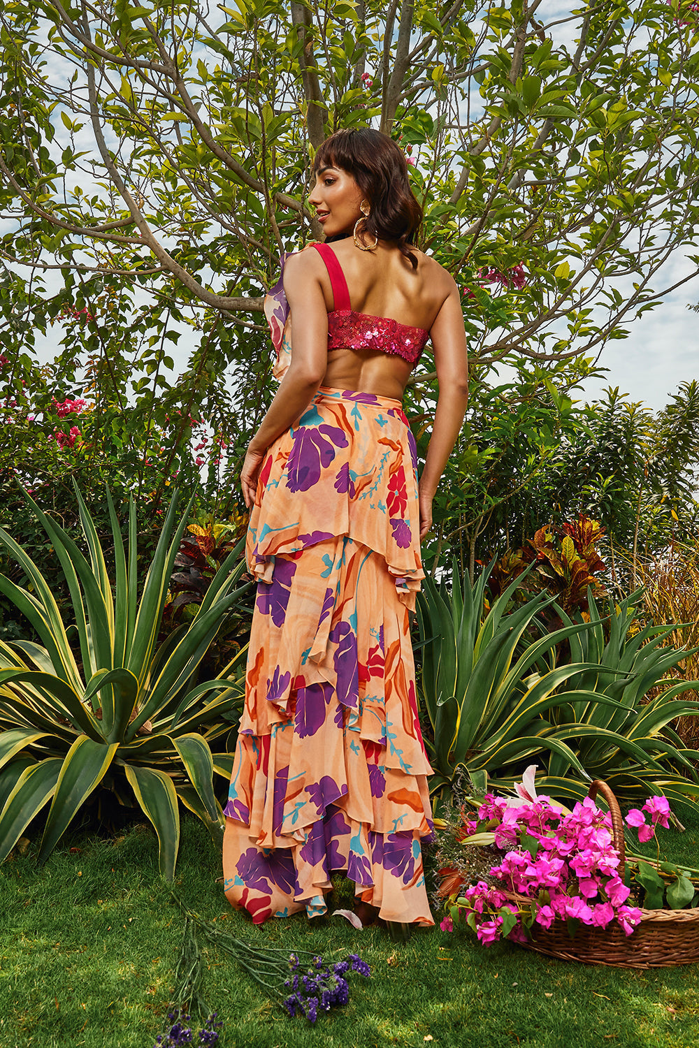 Cerise pink embellished bralette paired with floral printed ruffle saree.