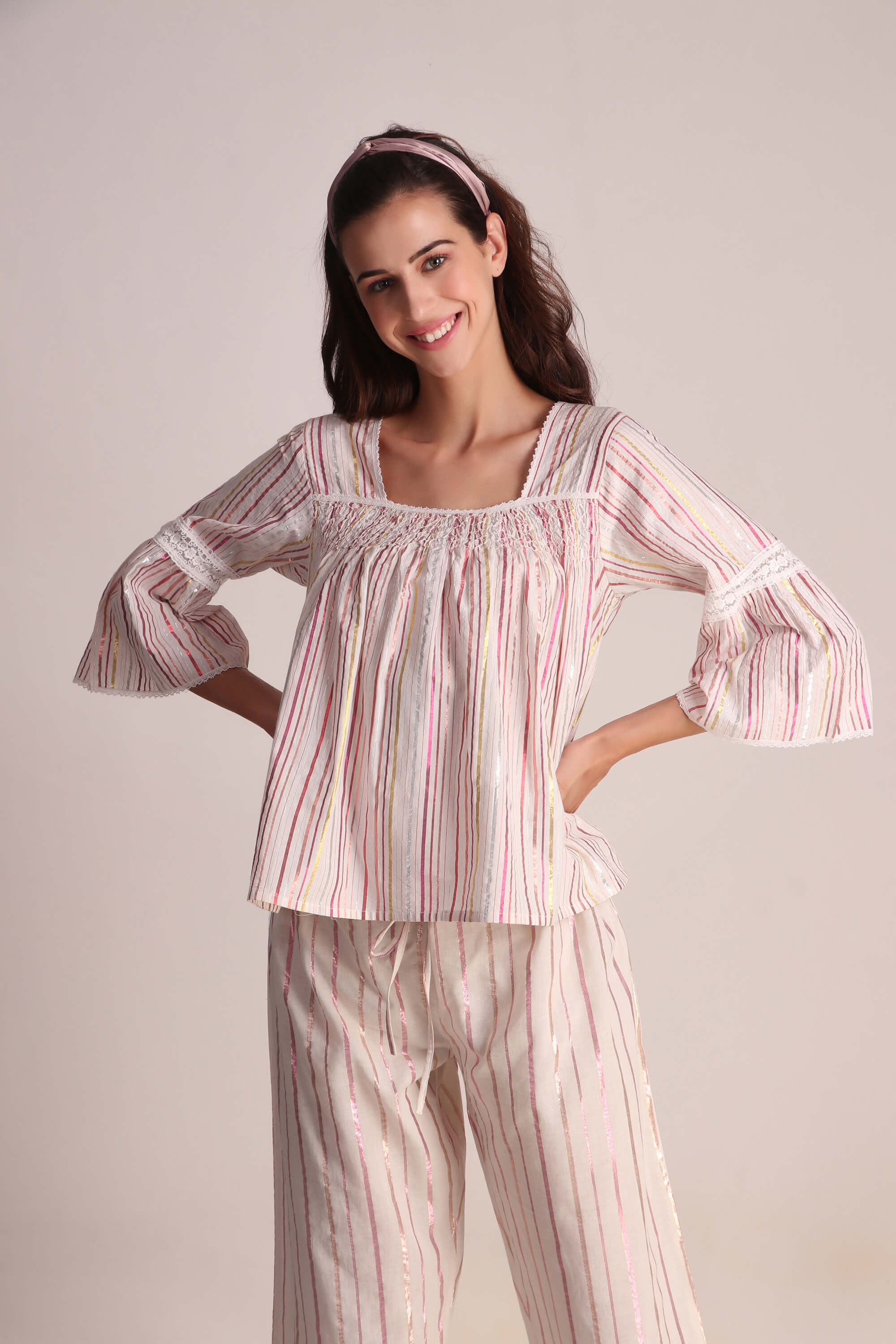 Smiling woman wearing stylish Opal pyjama suit with striped design.