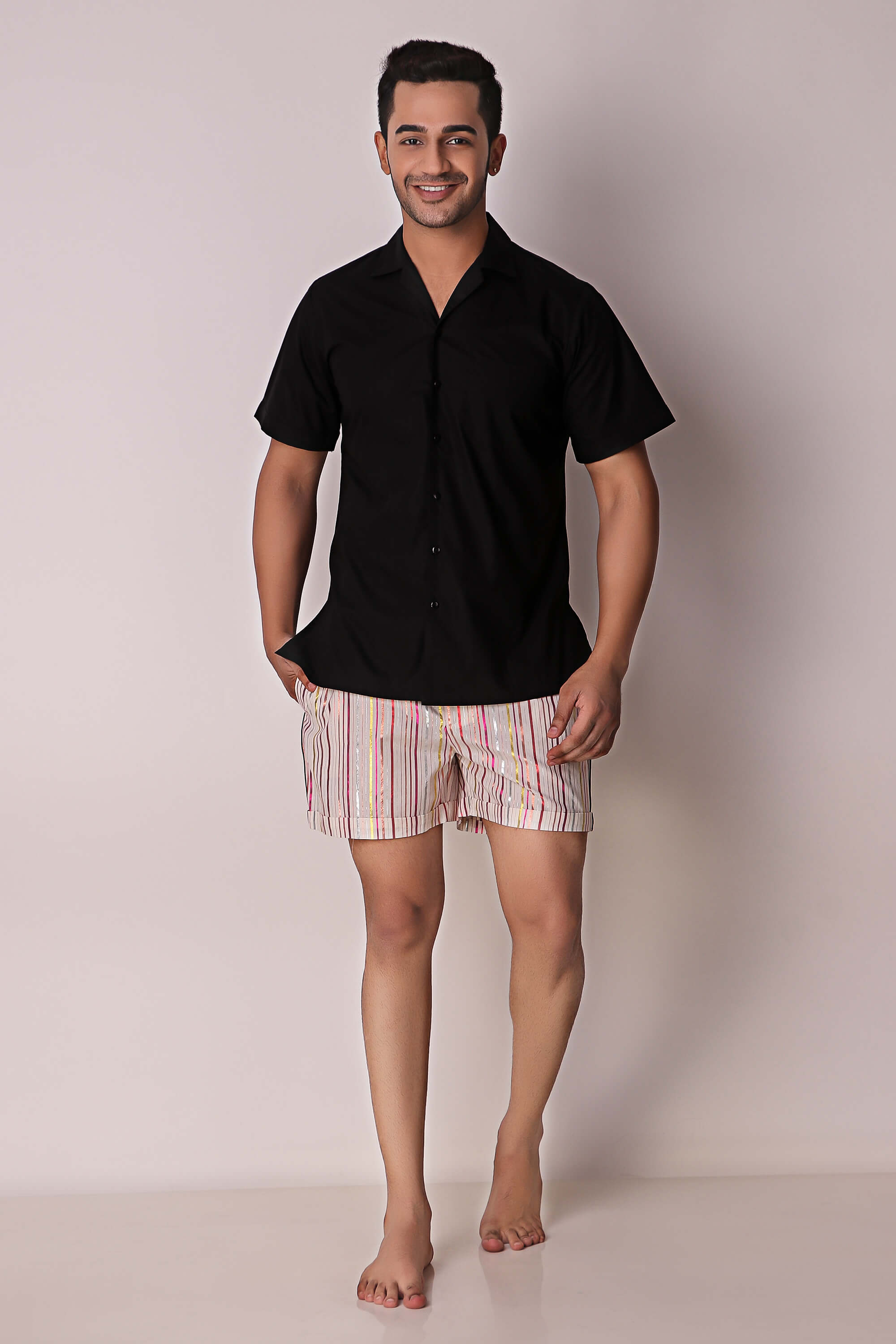 Men's shorts set in black shirt and patterned shorts.