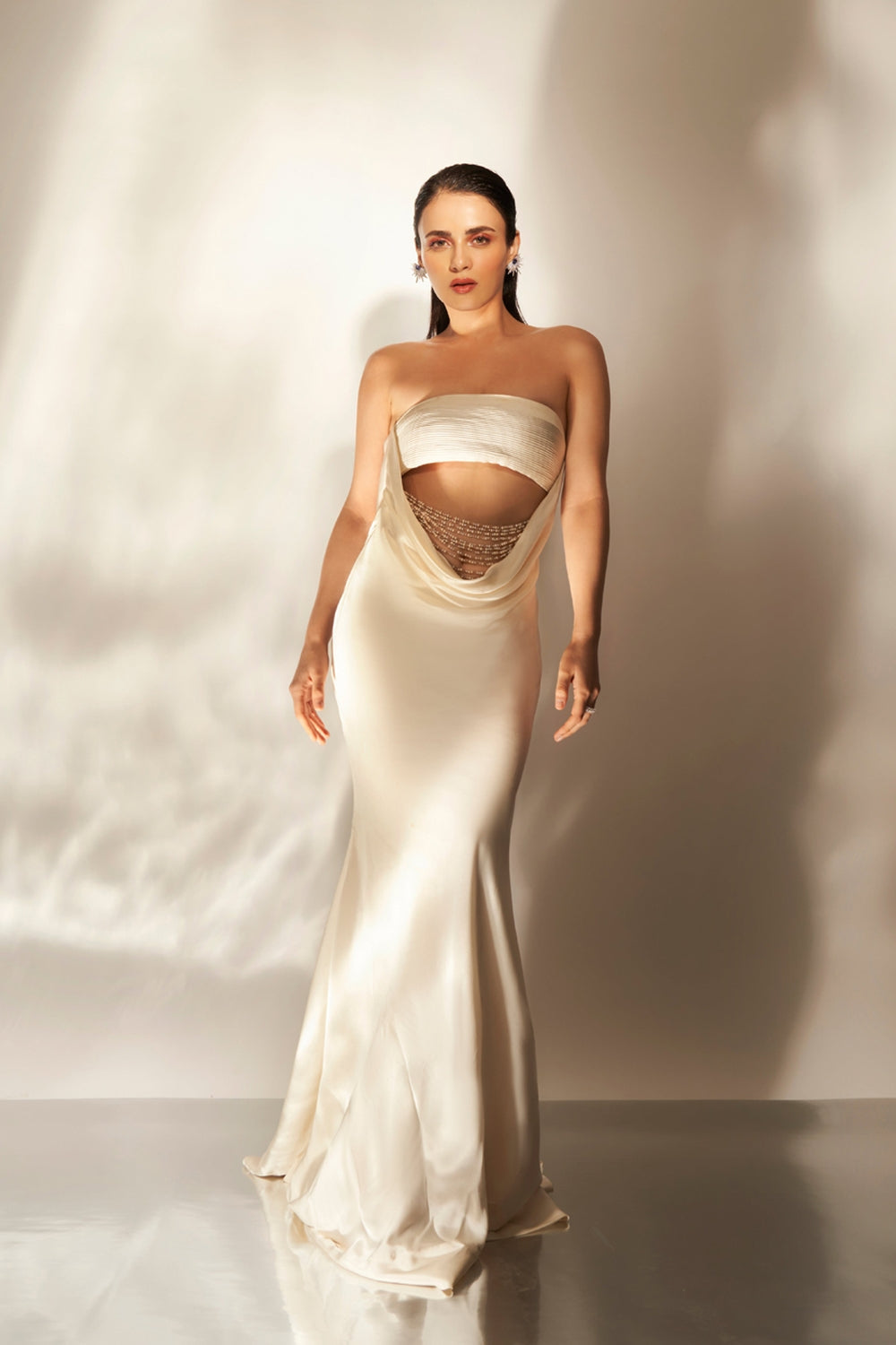 Ivory cowl gown with embellishments.