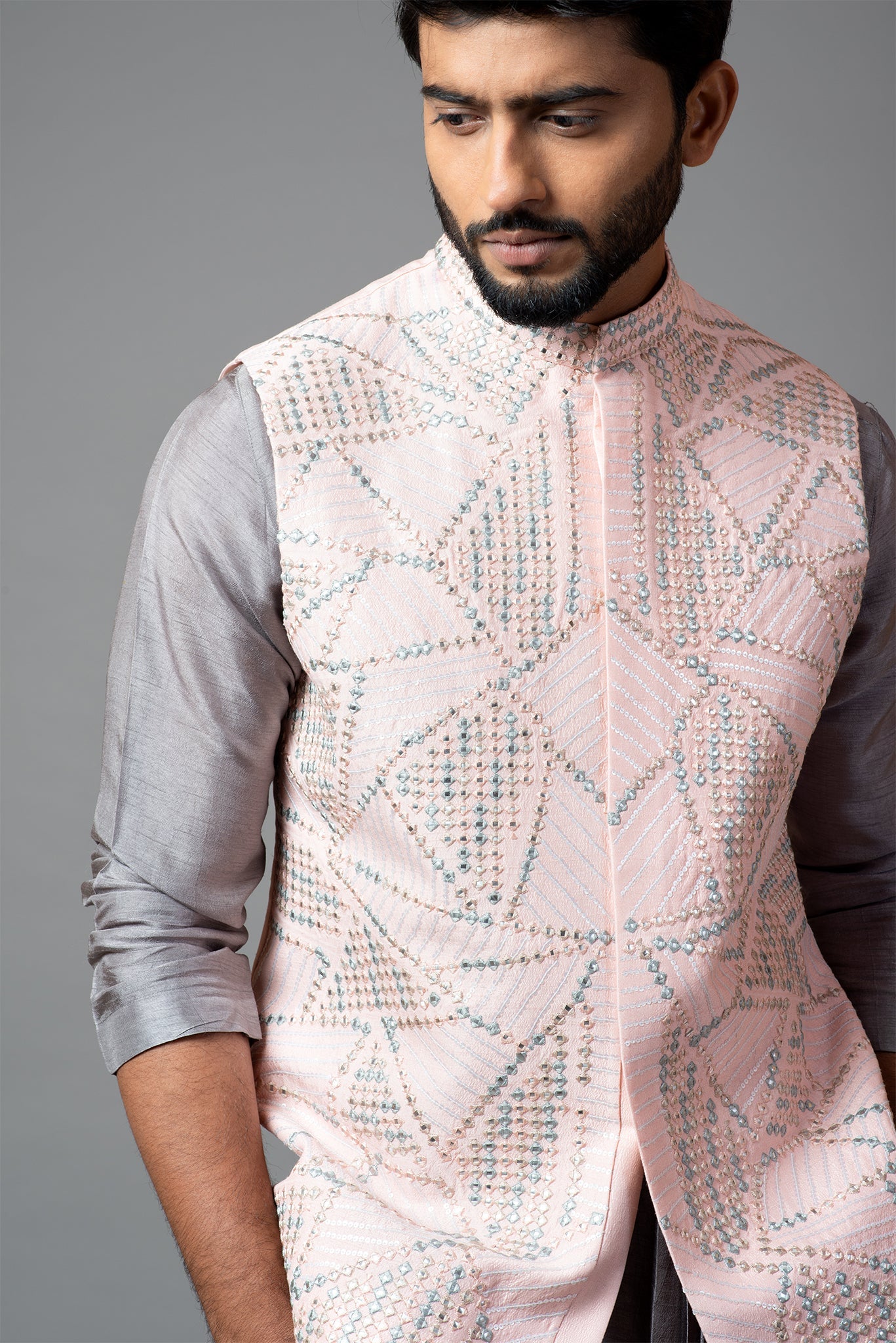 Powder pink Nehru jacket with geometric Mirrorwork embroidery paired with a slate grey drape kurta and pant pajama set