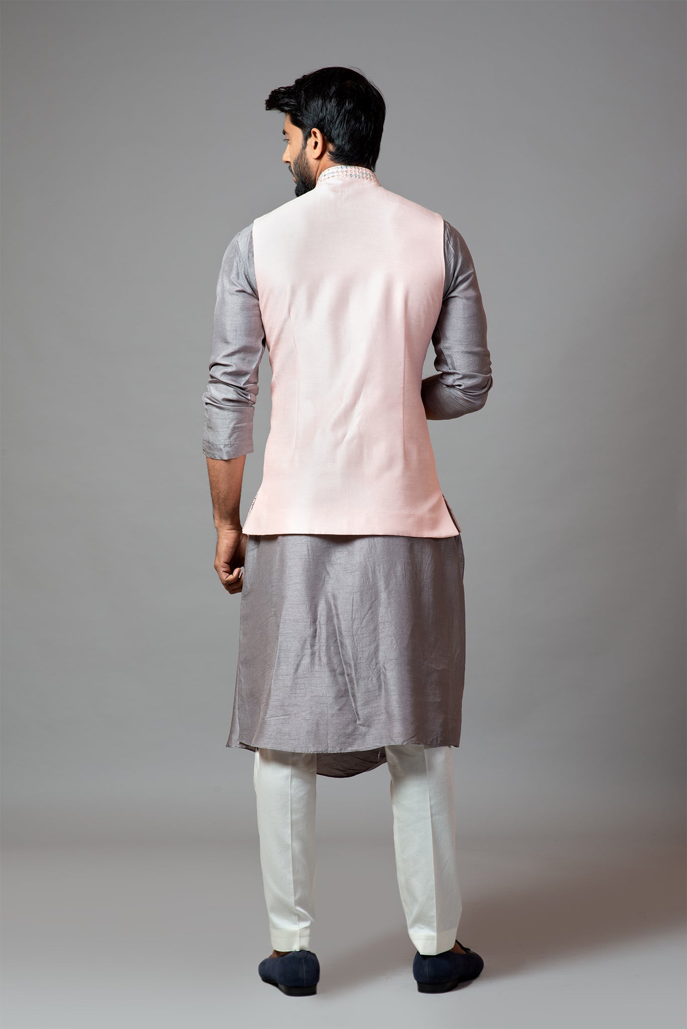 Powder pink Nehru jacket with geometric Mirrorwork embroidery paired with a slate grey drape kurta and pant pajama set