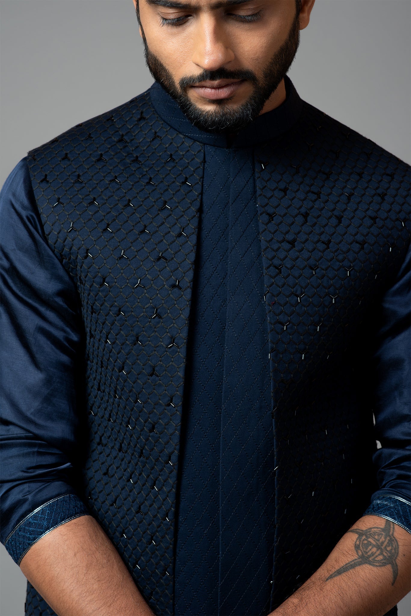 Navy blue Nehru jacket with Honeycomb pattern embroidery highlighted with panel detailing, paired with adrape kurta set